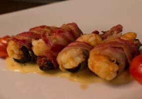 A plate of food with bacon wrapped around it.