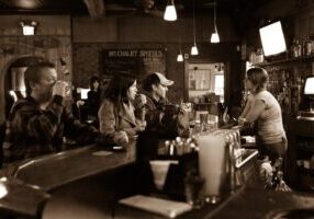 A group of people sitting at the bar.