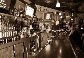 A man sitting at the bar of a restaurant.